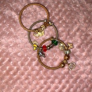 Three charm bracelets one silver and two gold